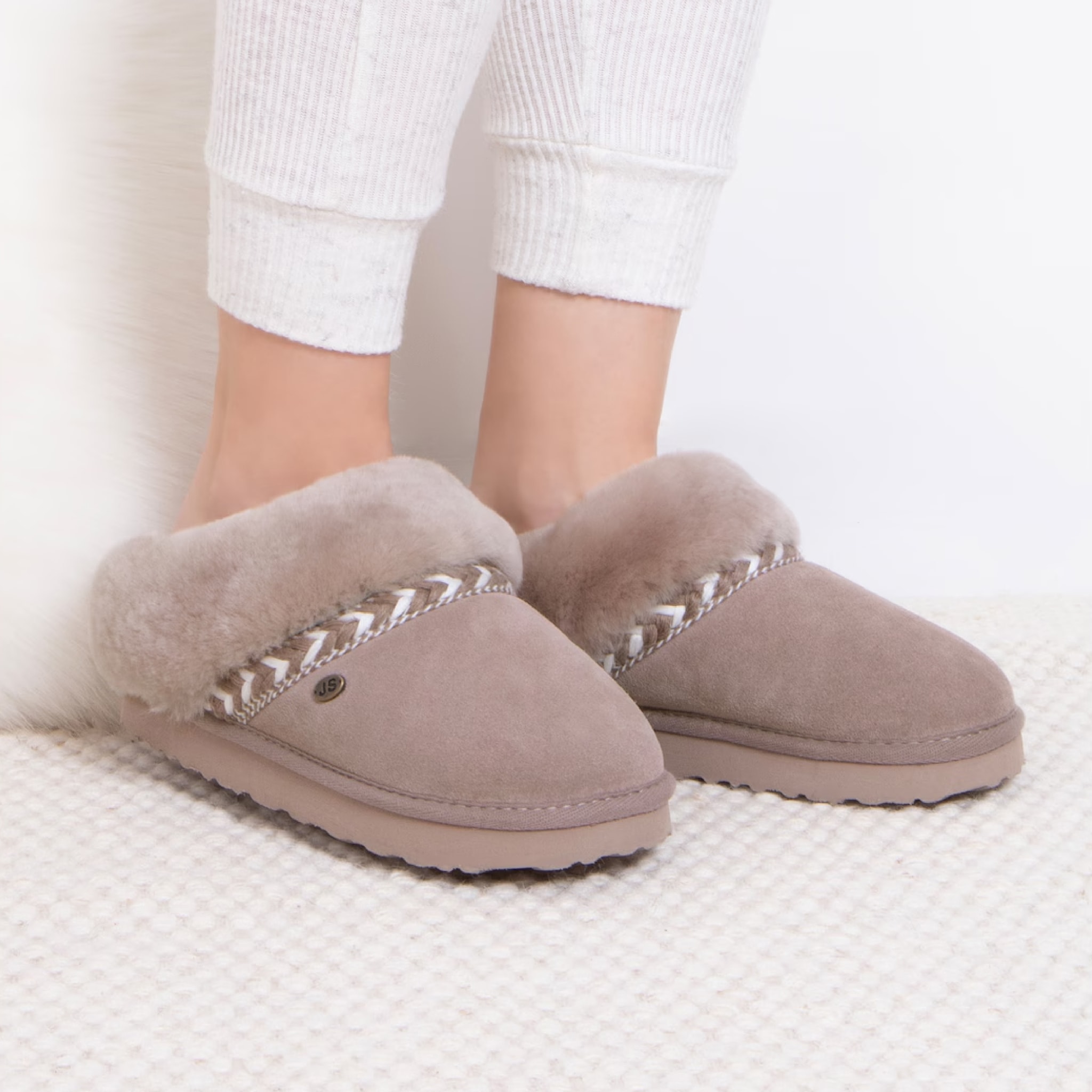 A pair of beige slippers with fluffy edge