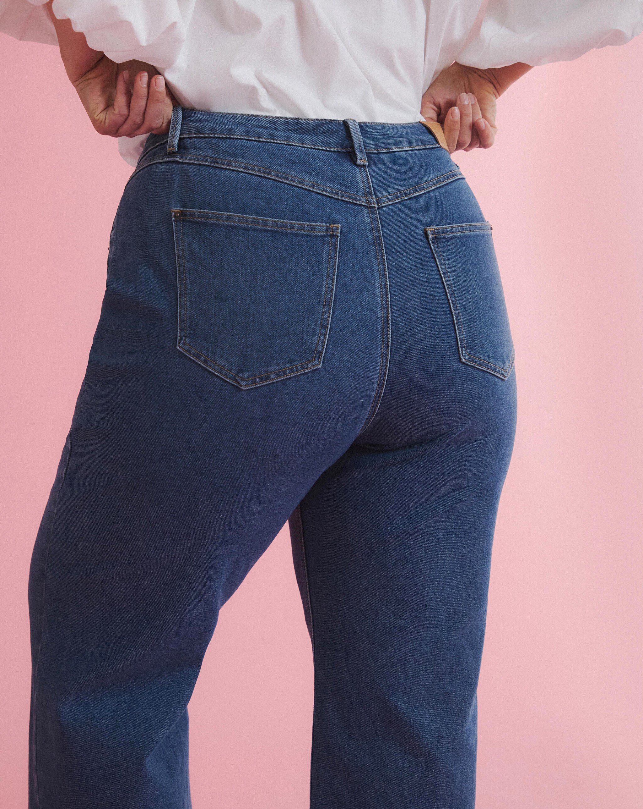 A close-up of a woman wearing blue jeans. 