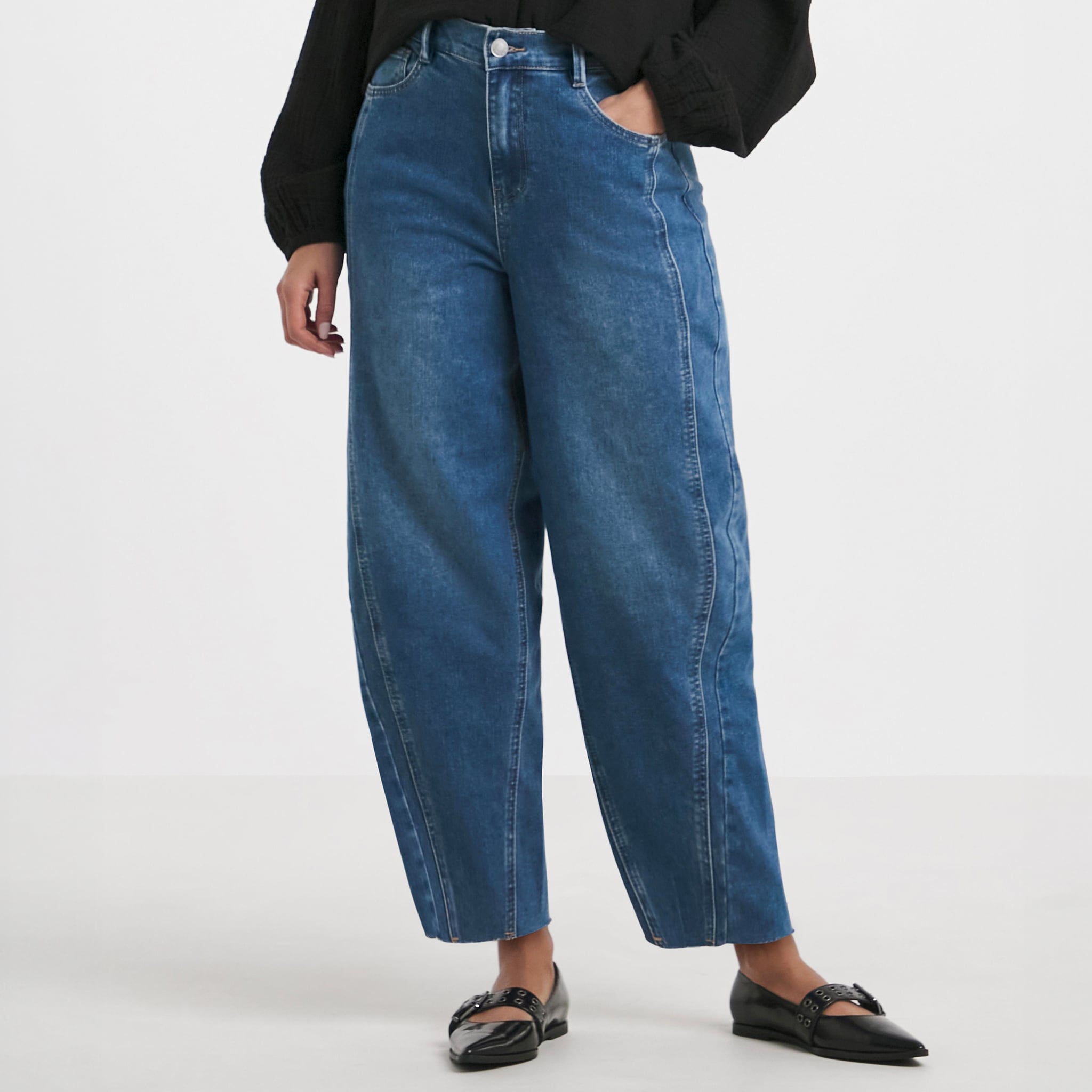 Model wears Mid Wash Barrel Leg Jean