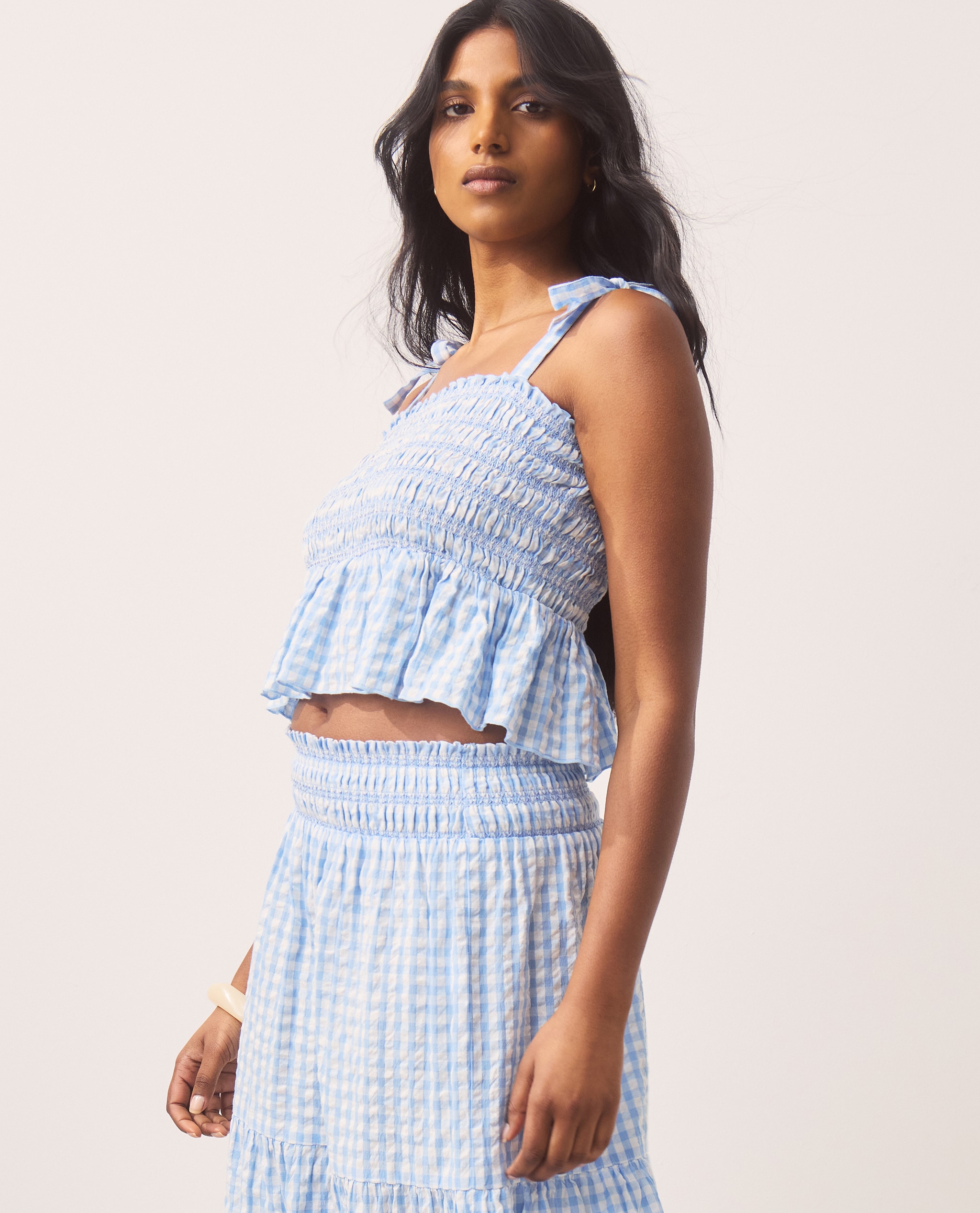 Model wears blue gingham co-ords