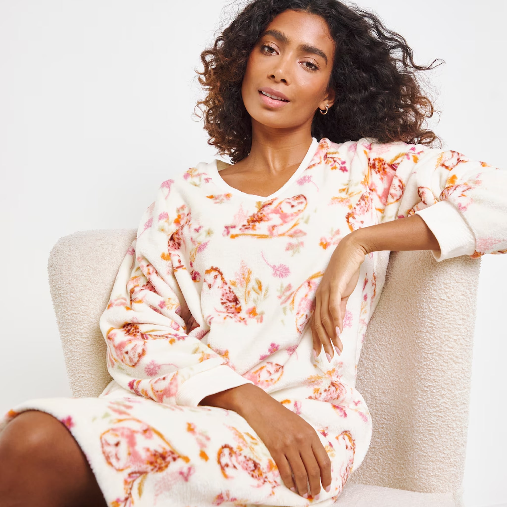 A woman sat wearing a white patterned nightie