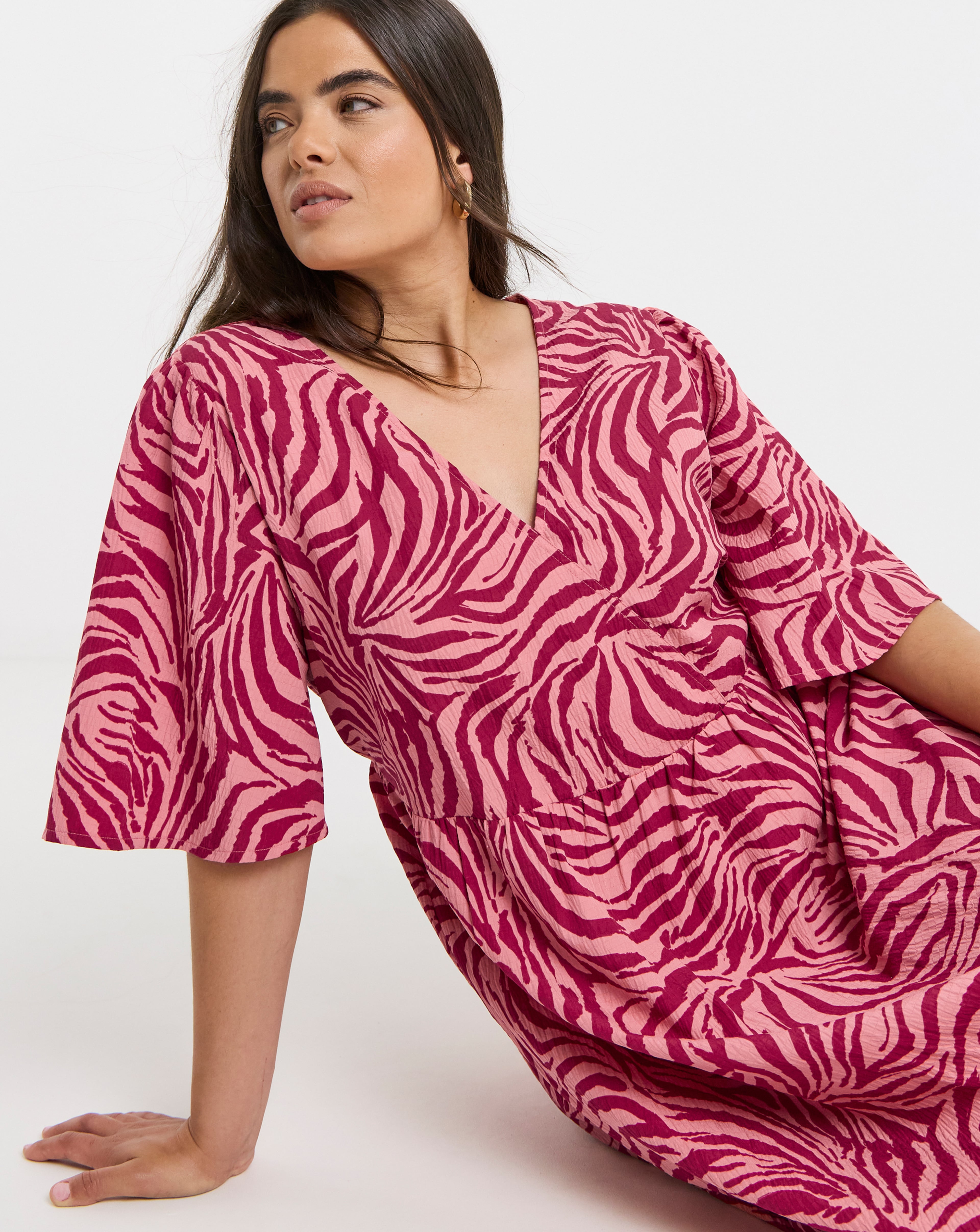 Person wearing a Simply Be midi dress with a pink print.