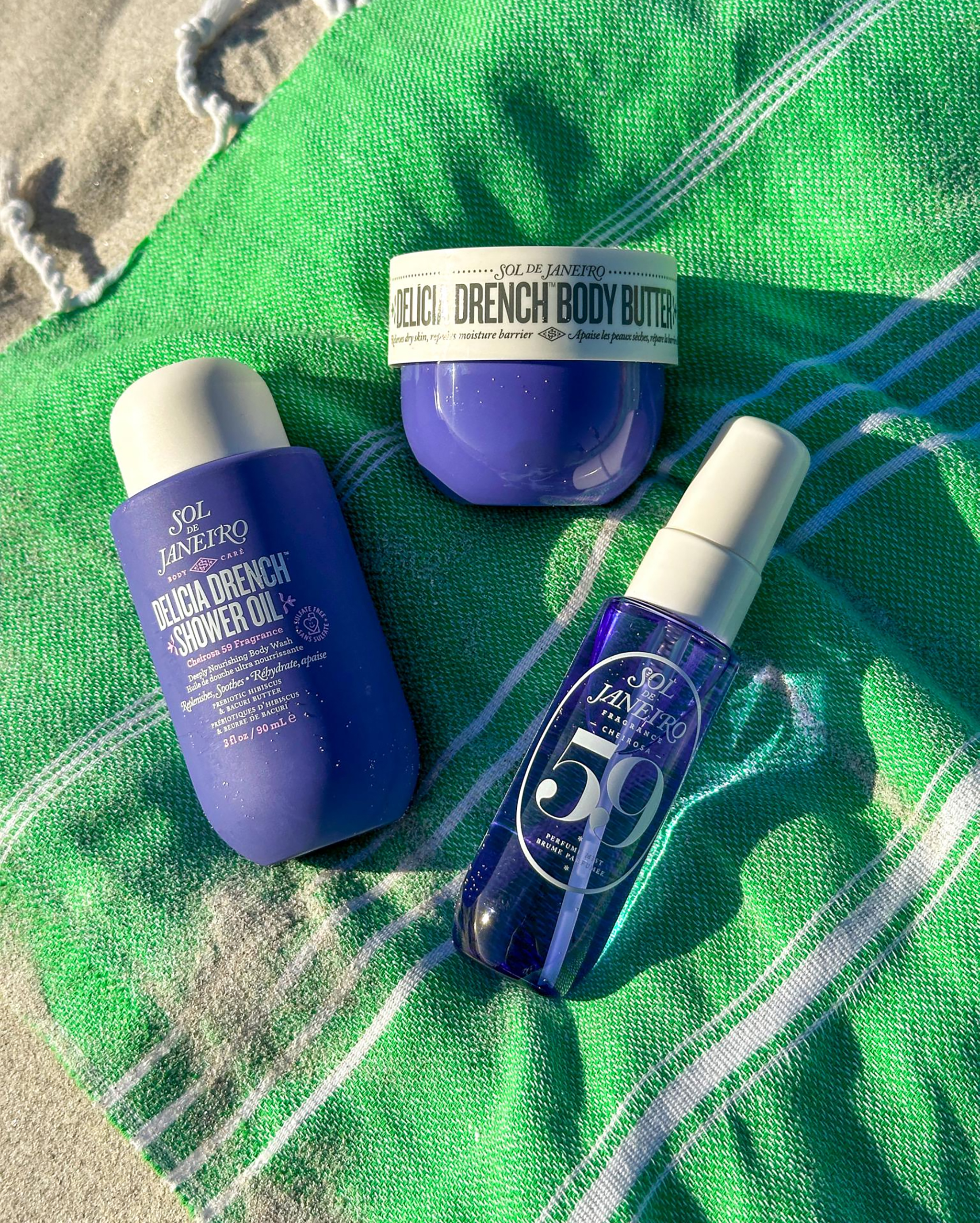 Sol de Janiero beauty products on a green beach towel.