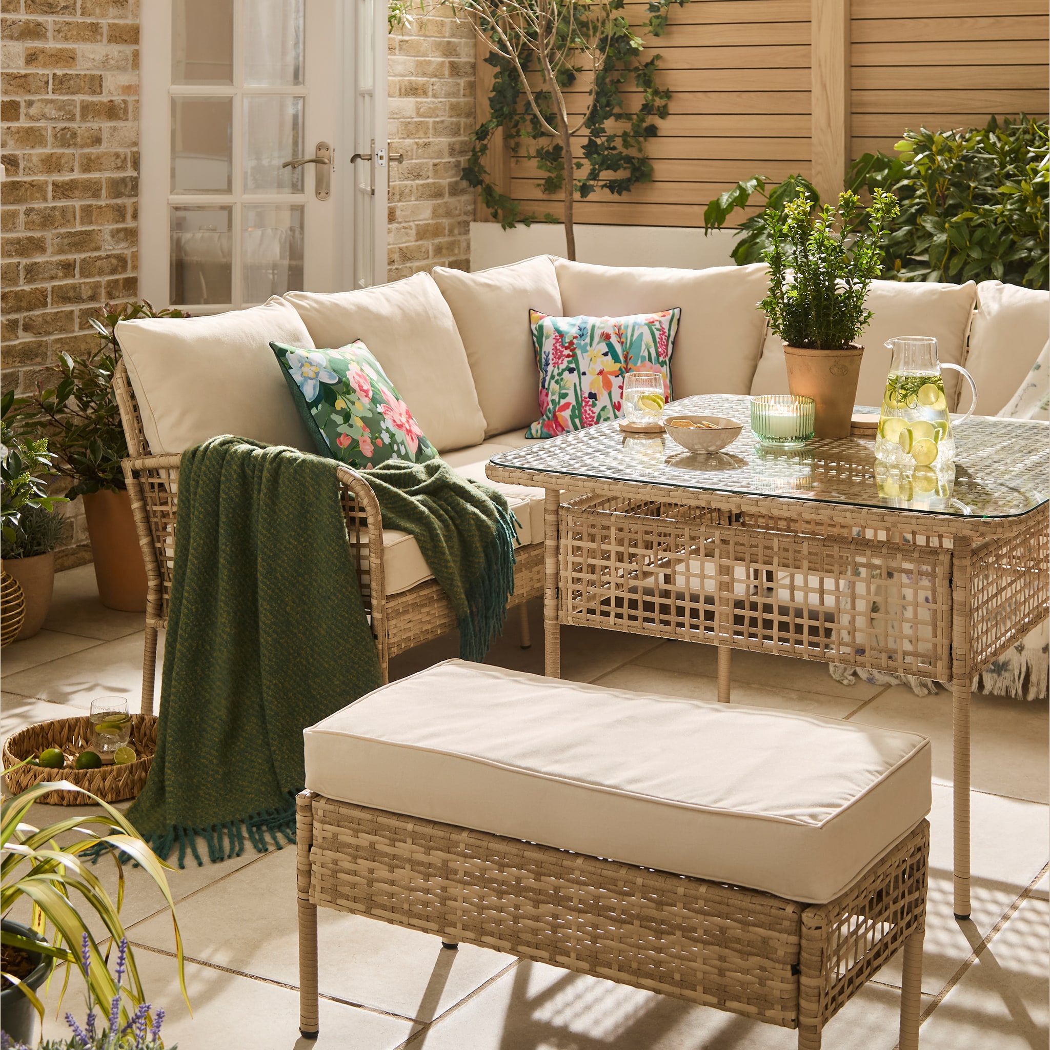 A garden scene with an L shaped corner sofa and table