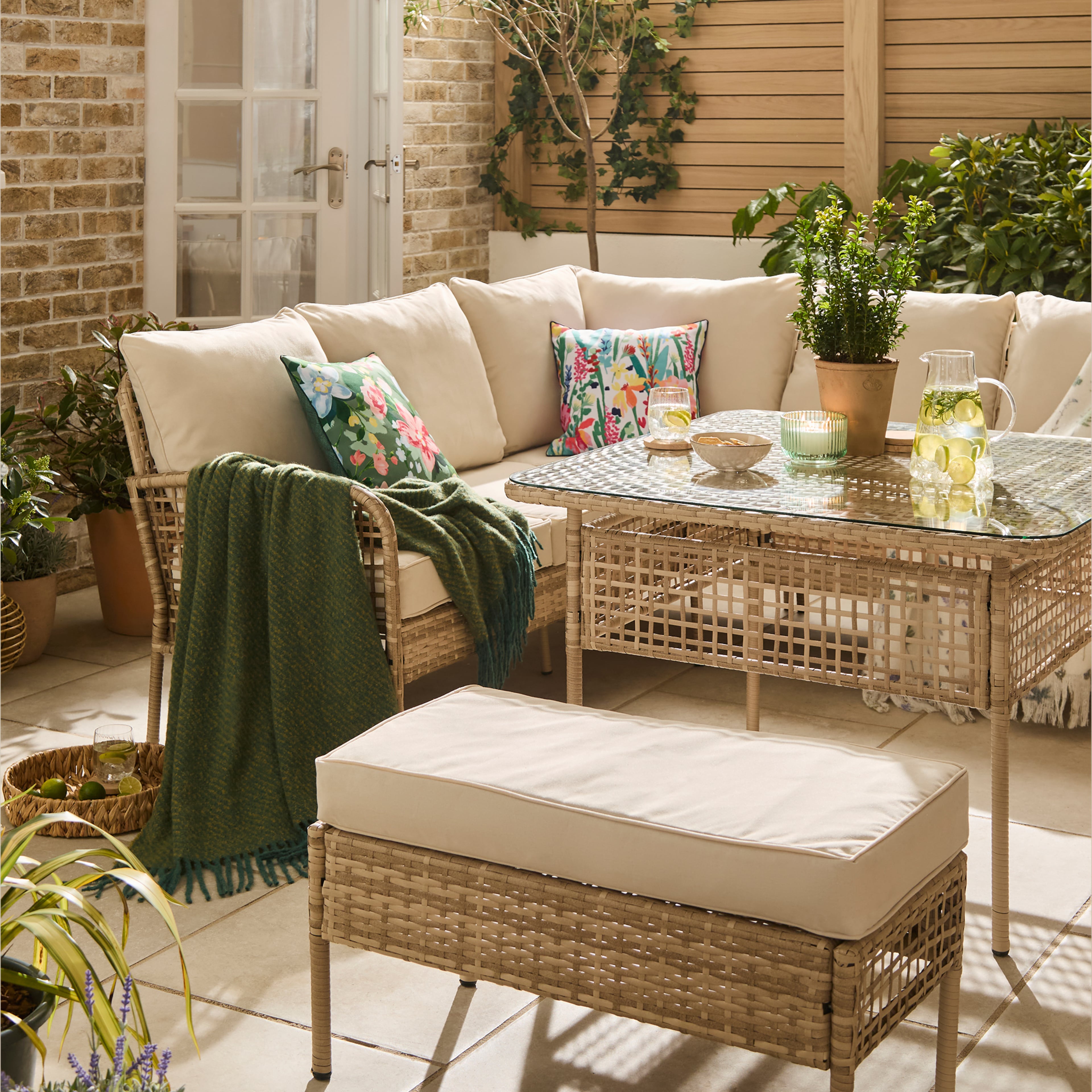A garden scene with an L shaped corner sofa and table