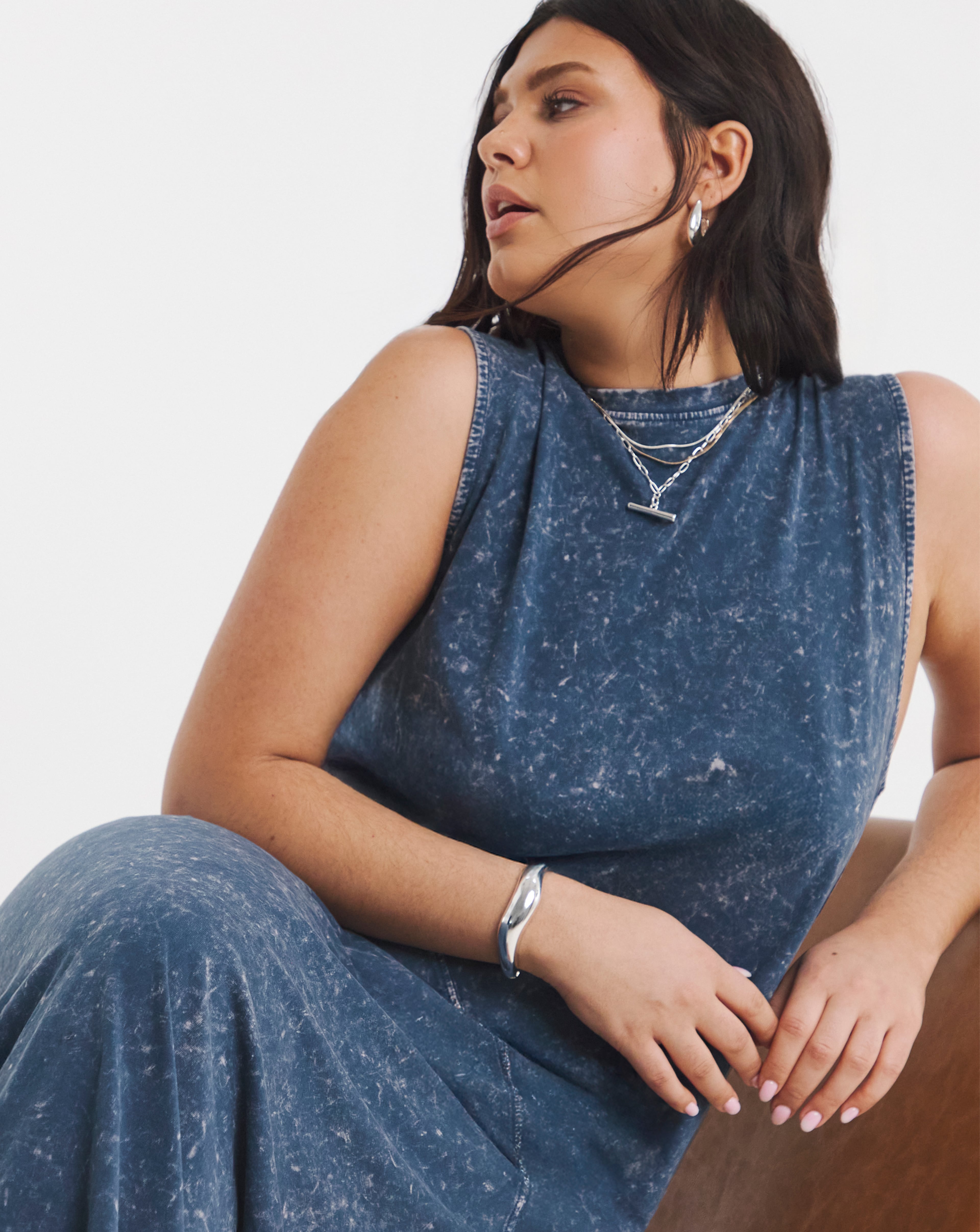 A seated person wearing an acid wash maxi dress.