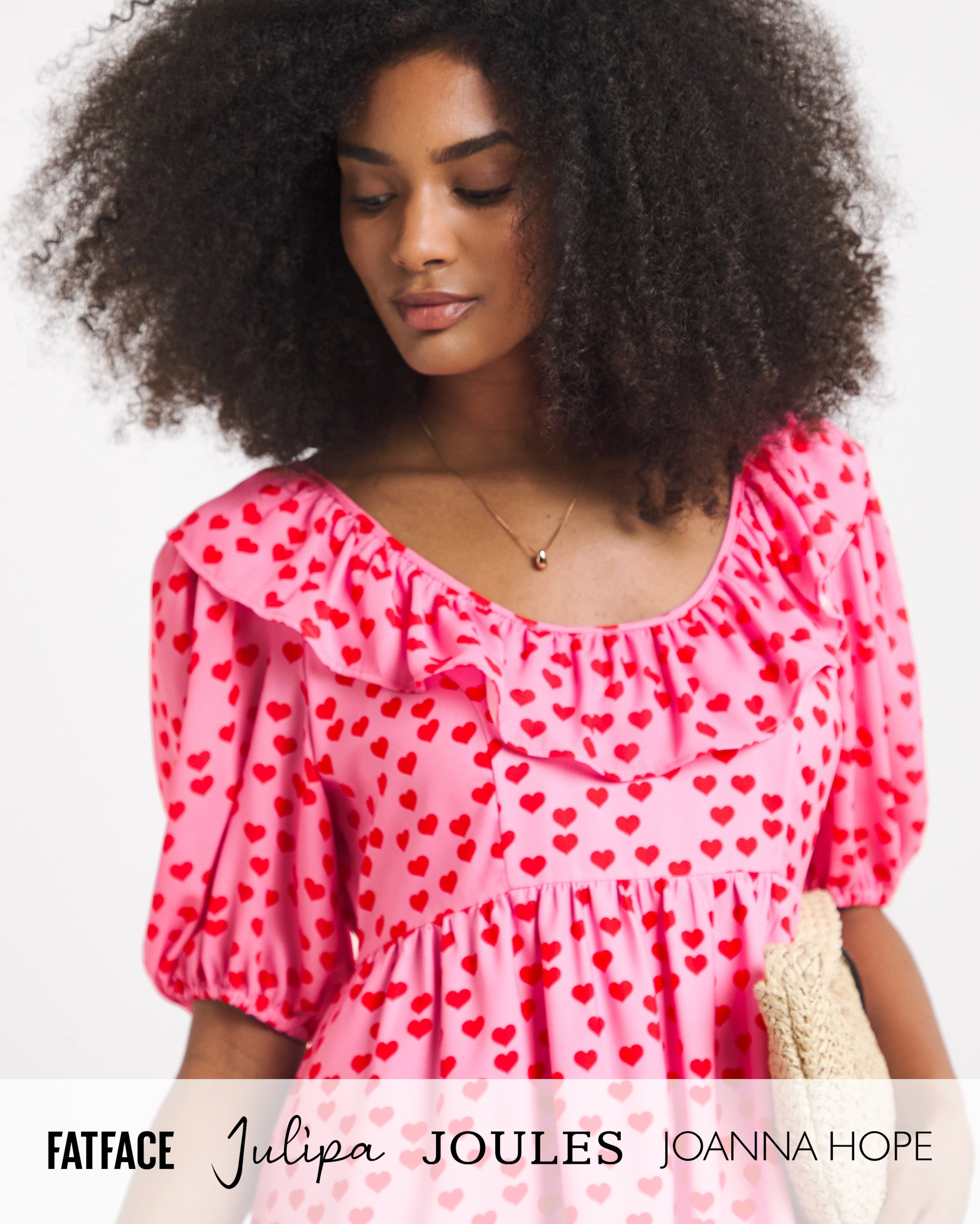 Person wearing a pink Twisted Wunder mini dress with a red heart print, carrying a clutch bag. Brand logos displayed along the bottom.