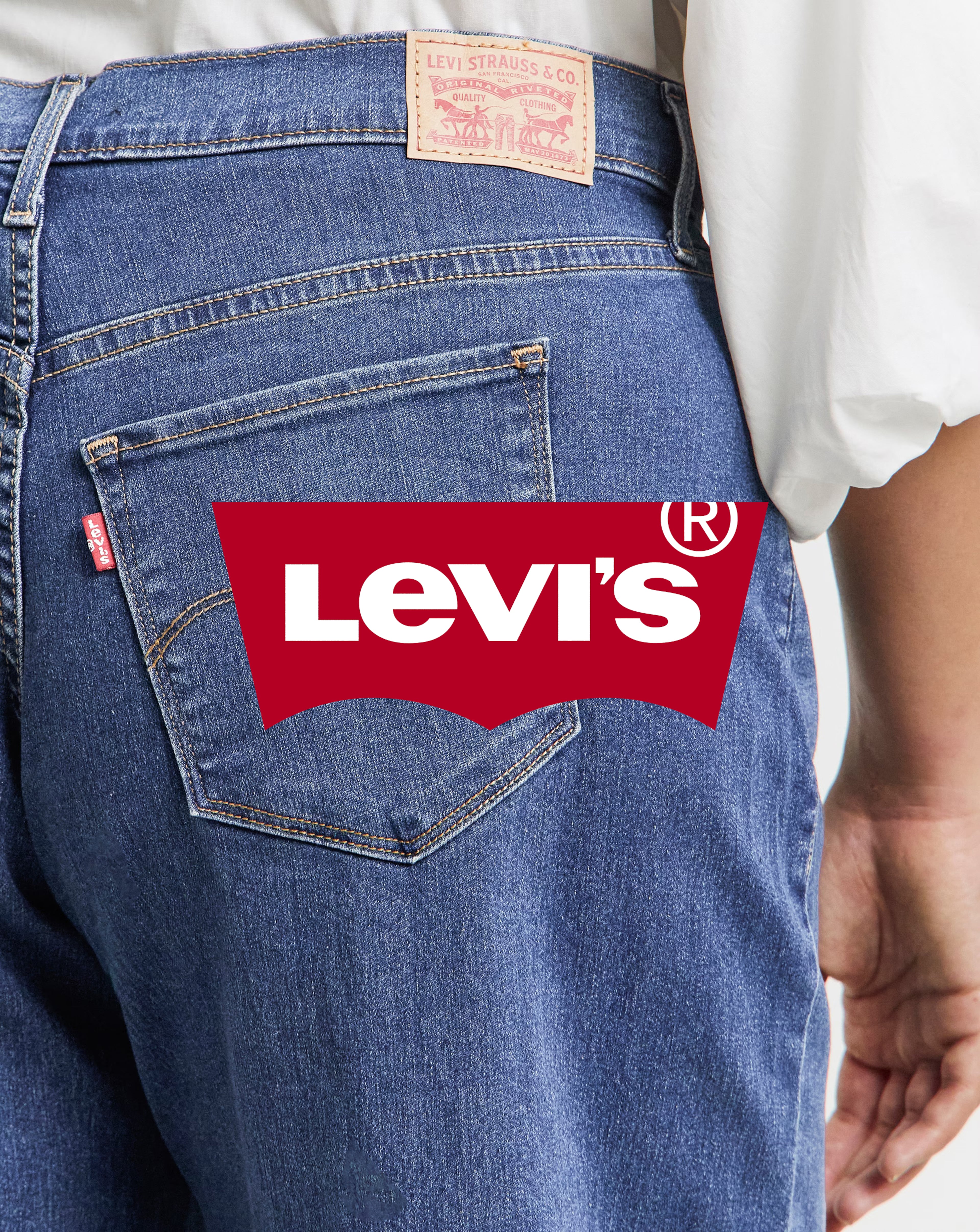 Close-up of blue denim jeans and Levi’s logo overlaid.