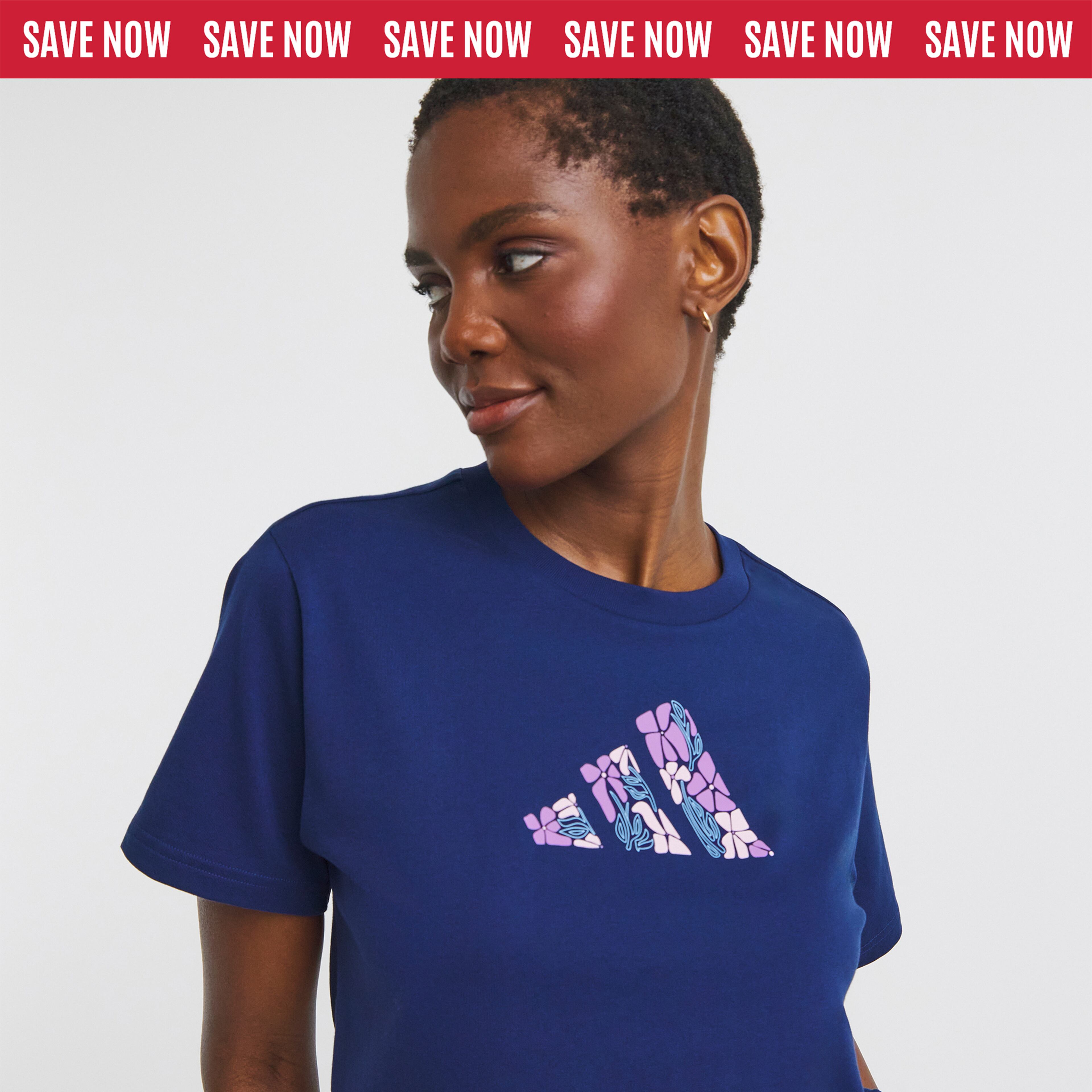 Person wearing a navy-blue T-shirt with a floral-patterned Adidas logo on the chest.