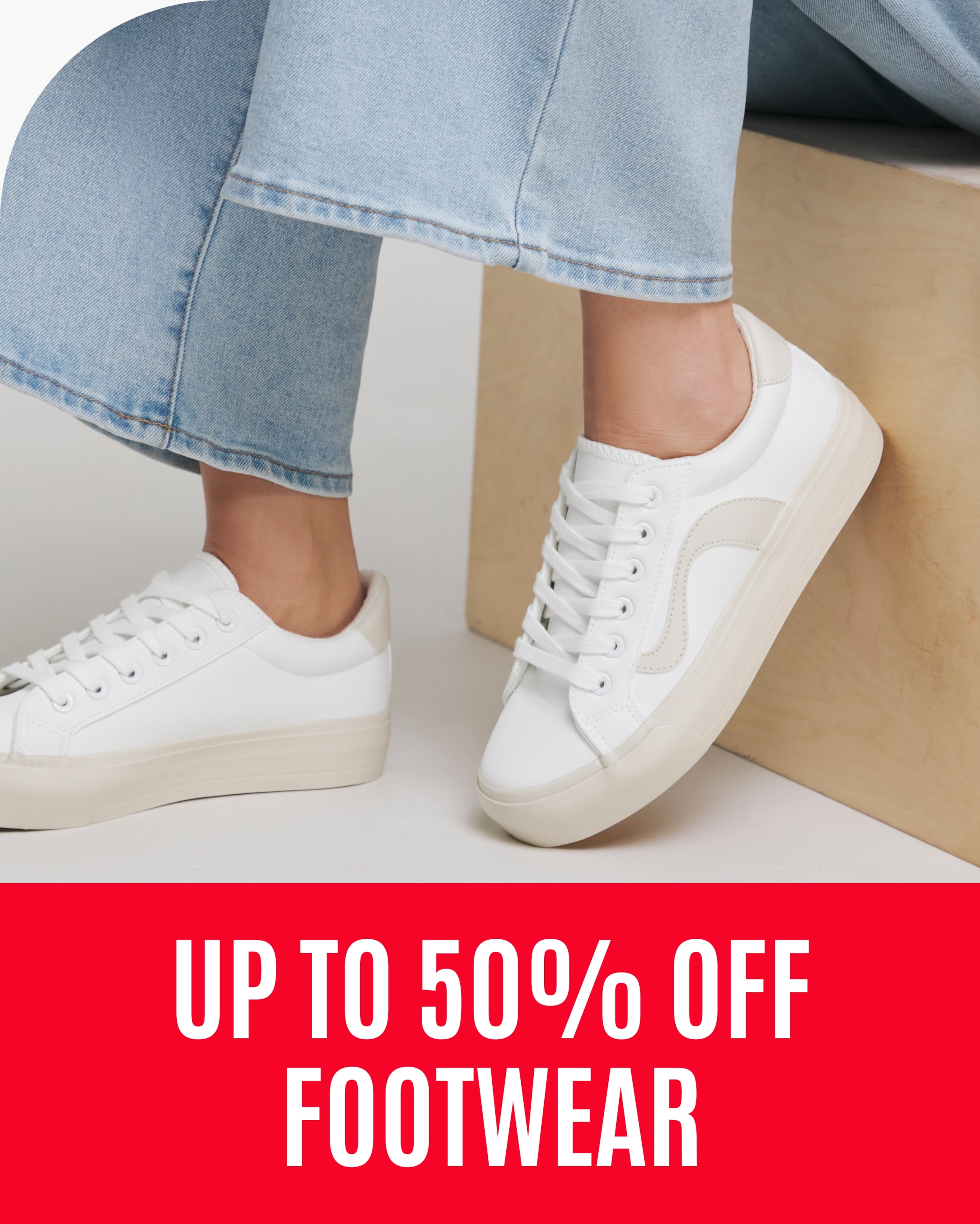 A person sat while wearing white Chicago Retro Runner Trainers.