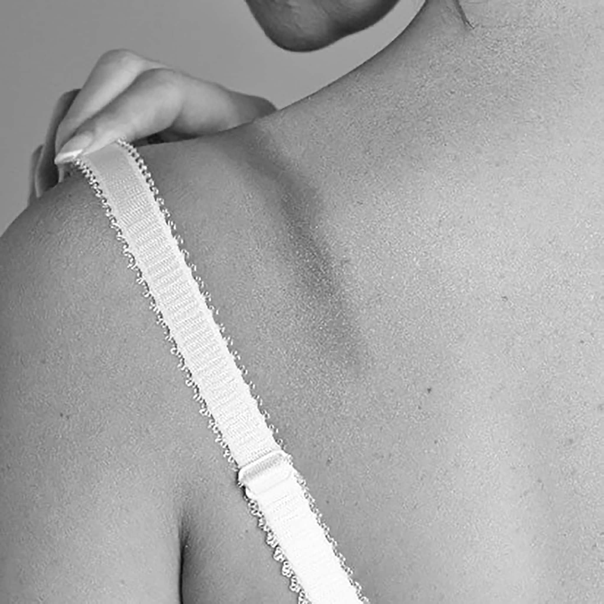 A woman wearing white bra showing straps digging in