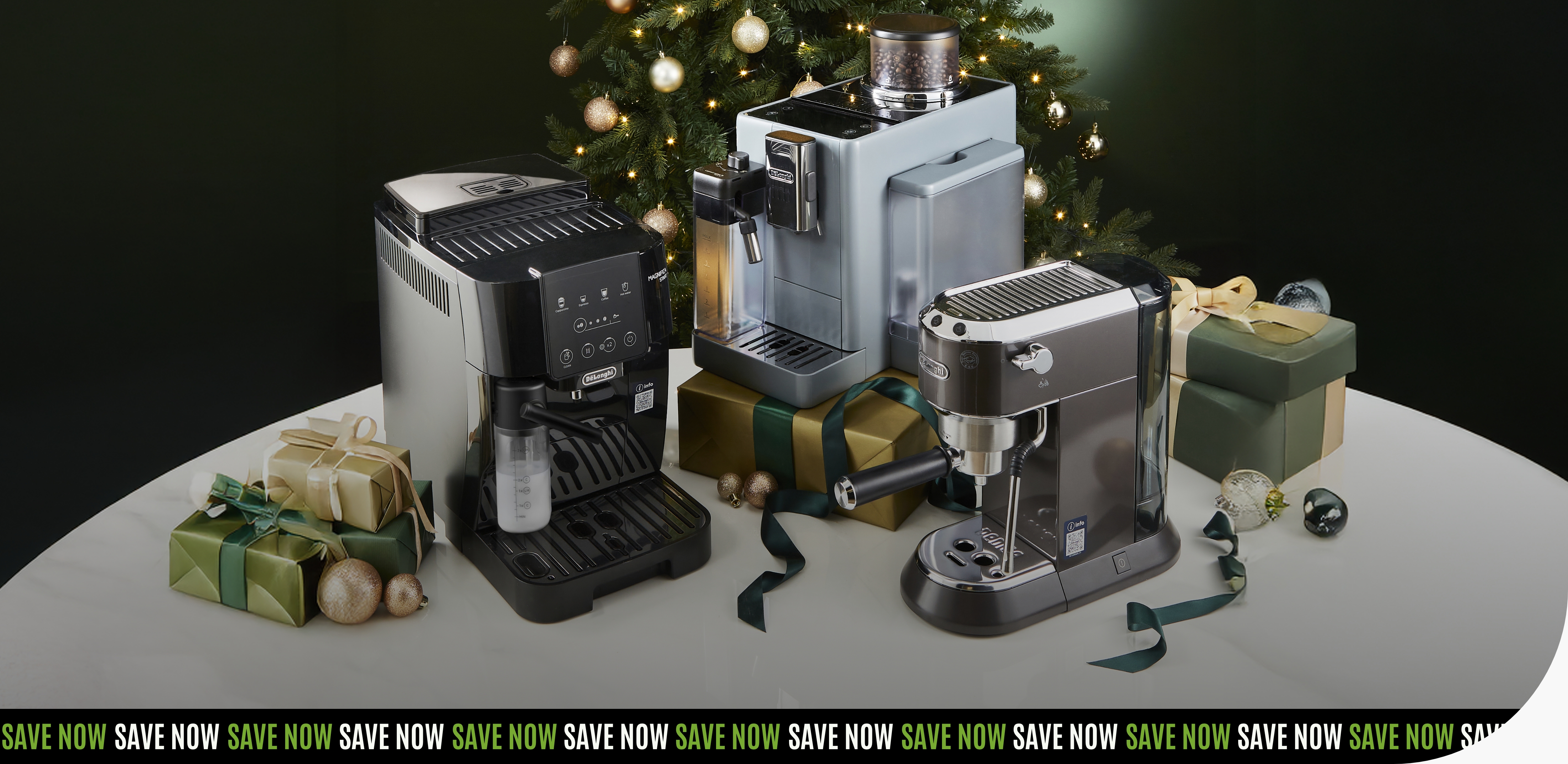 Three varying models of bean-to-cup coffee and espresso machines displayed on a table with holiday gift boxes.
