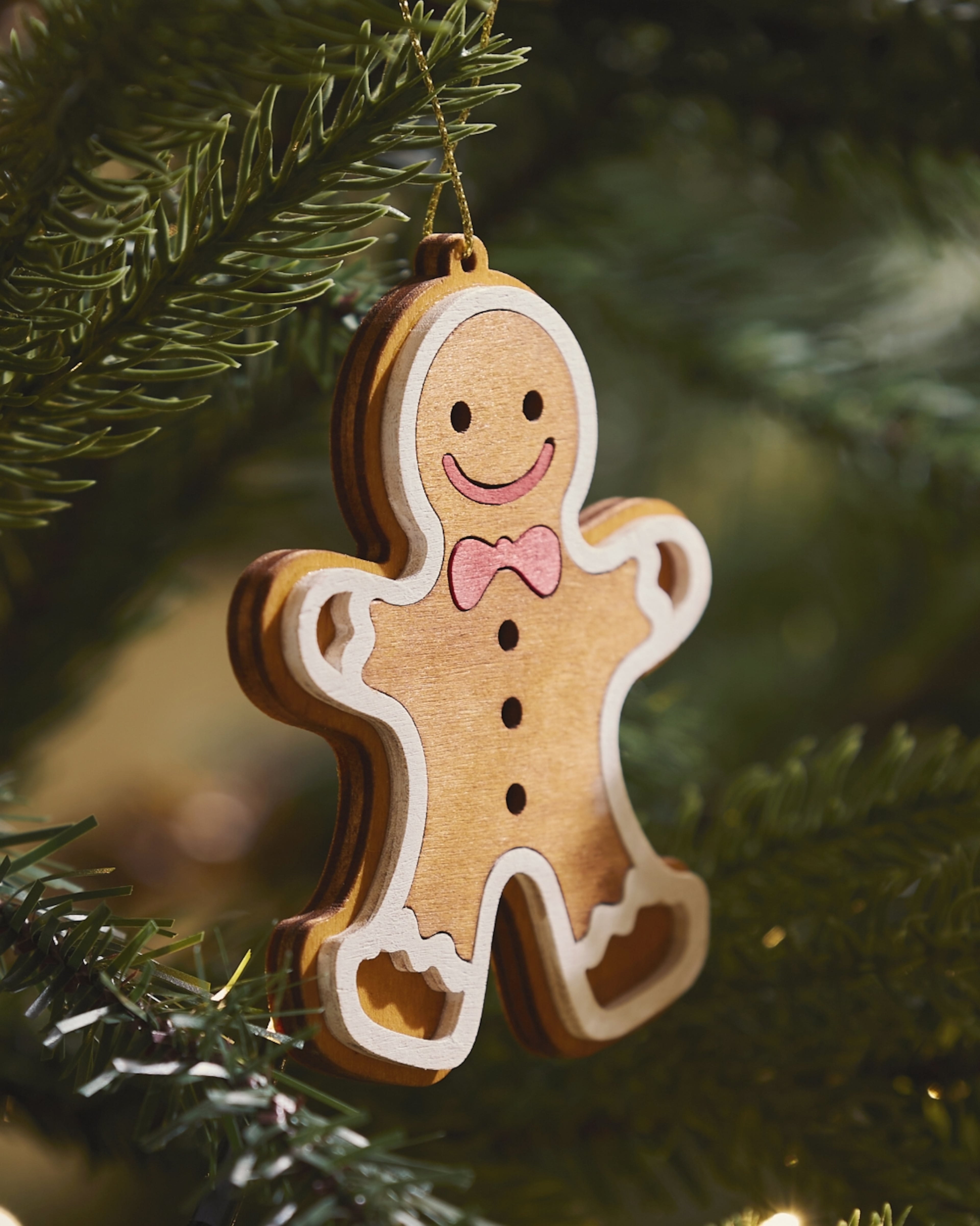 Gingerbread Man Ornament Hanging On Christmas Tree Decorates Joyful Holiday Scene With Warm Cheer