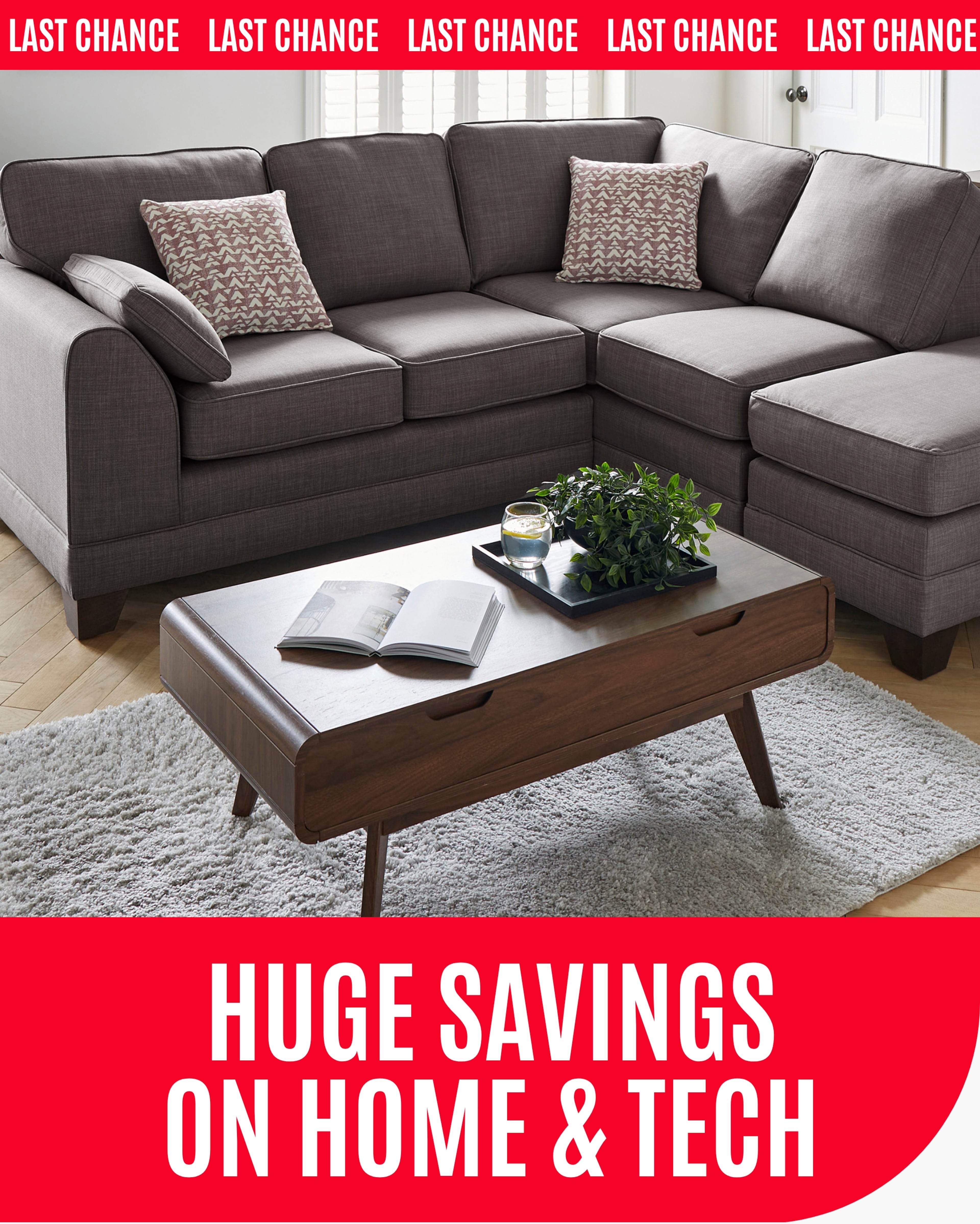 A grey sofa with patterned throw pillows and a wooden coffee table in a bright living room.