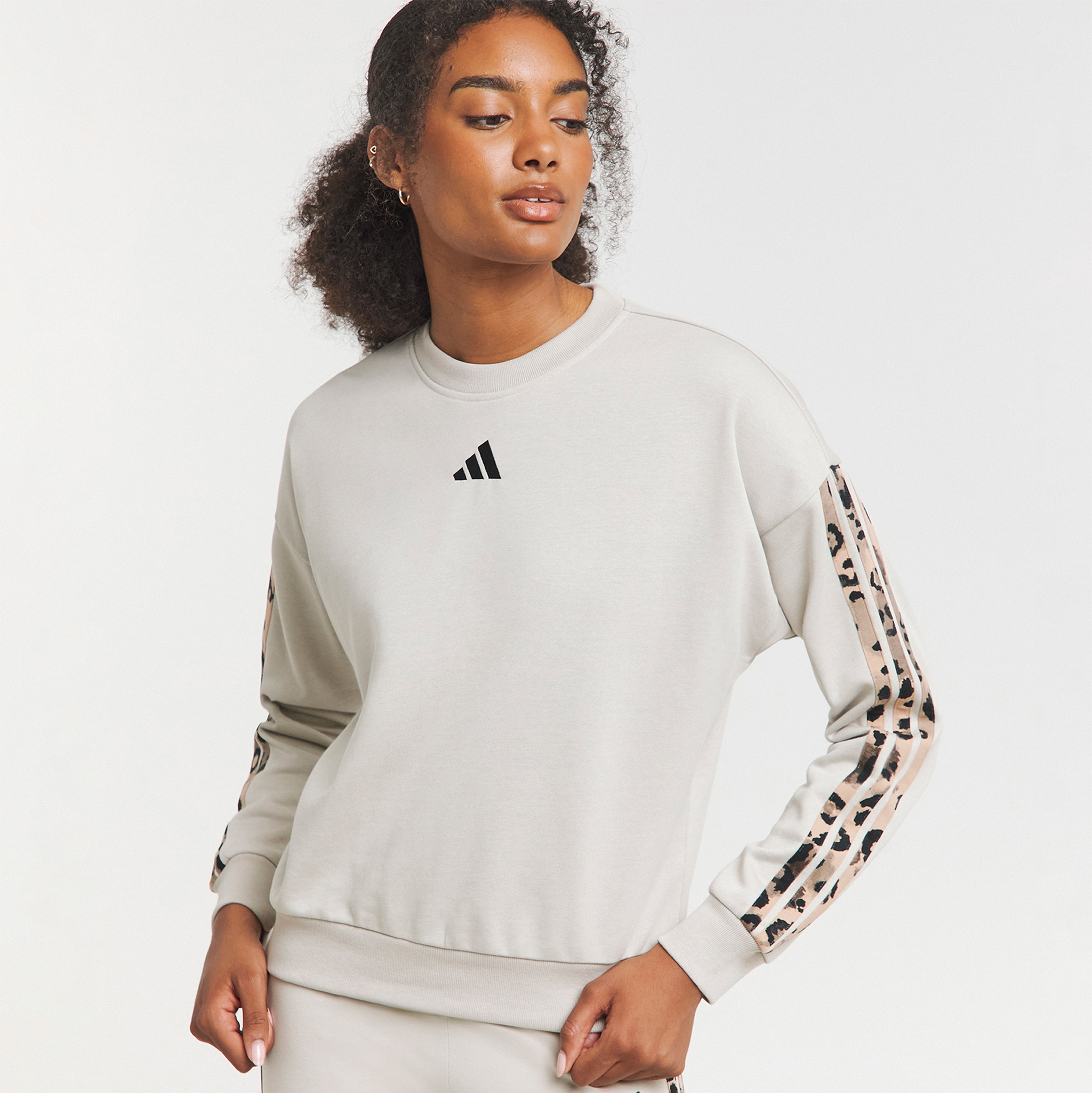 A model wearing an Adidas leopard print 3-stripe sweatshirt.