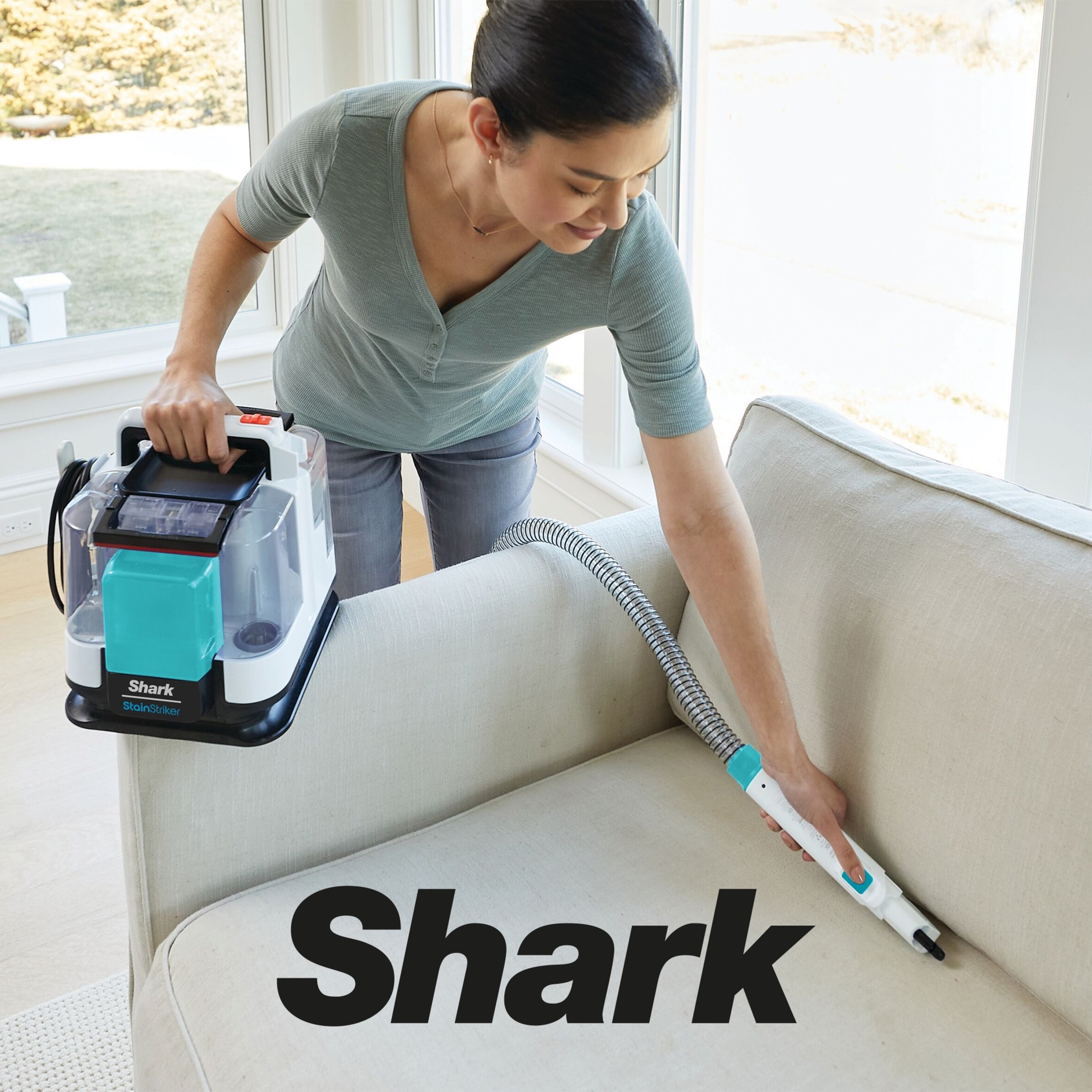 A woman using the Shark StainStriker Stain & Spot Cleaner