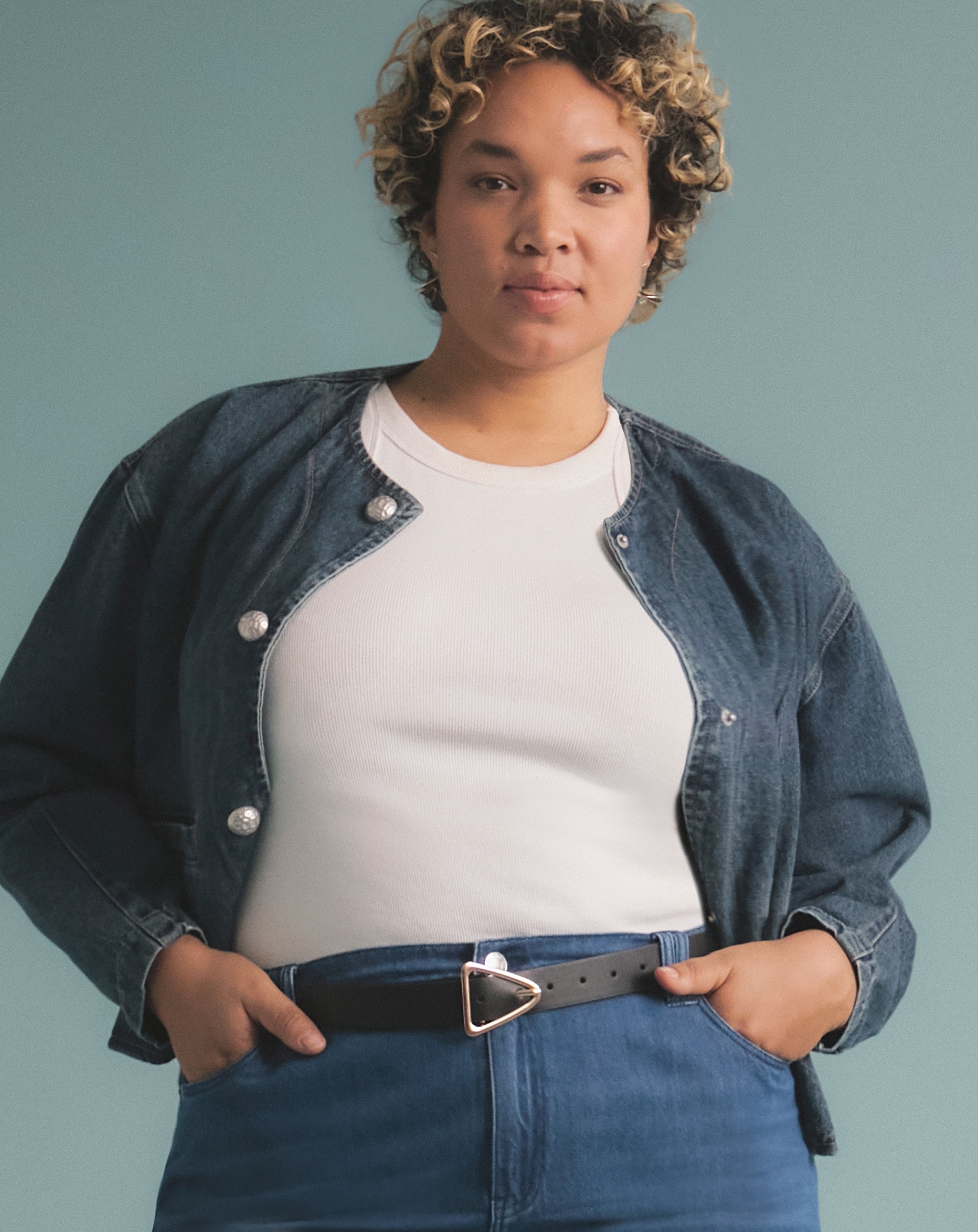 A woman wearing a dark denim shirt over a white t-shirt