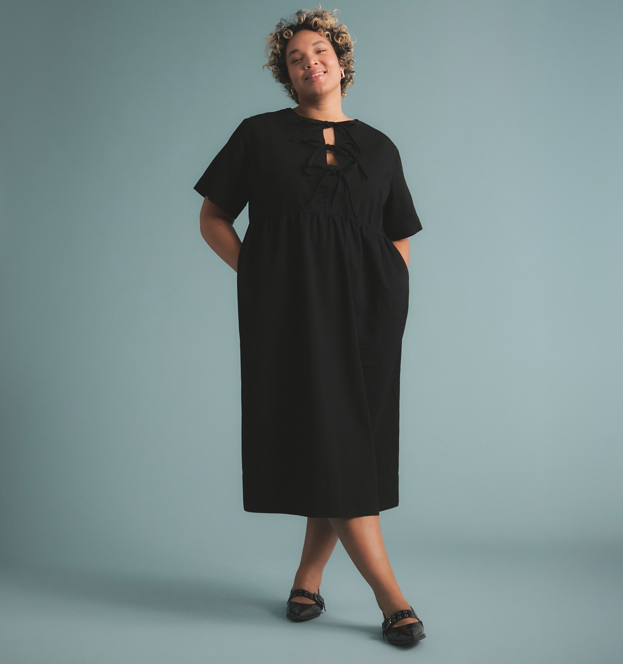 A woman stood wearing a black denim dress