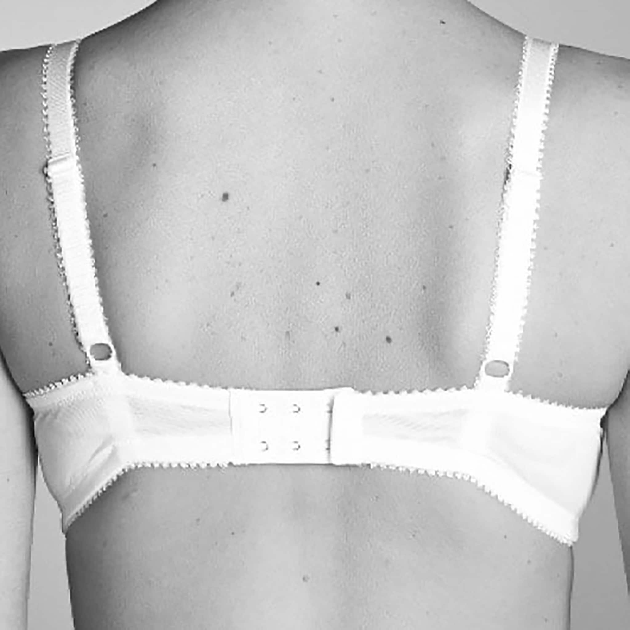 A woman wearing white bra showing back band riding high